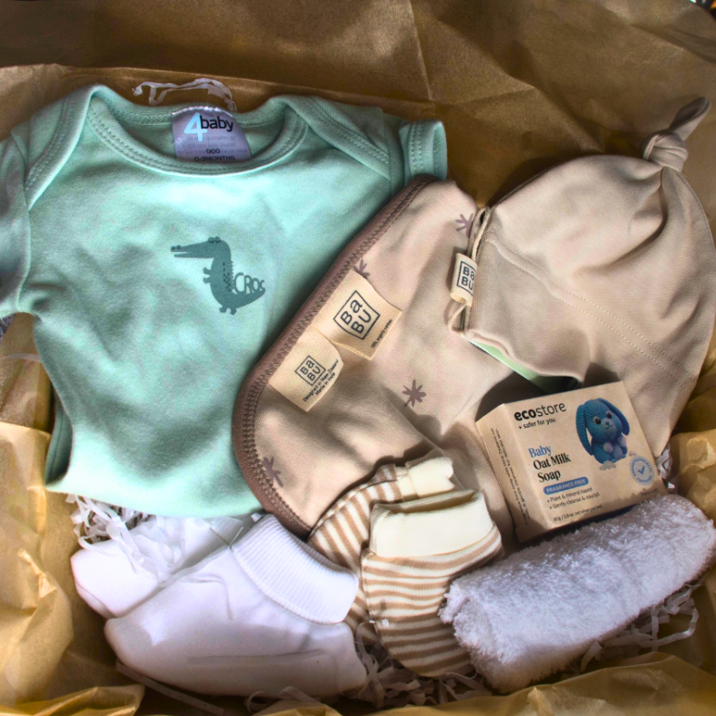 Newborn gift box NZ with baby essentials including onesie, hat, bib and booties
